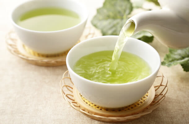 暖かい緑茶を急須で注いでいる画像