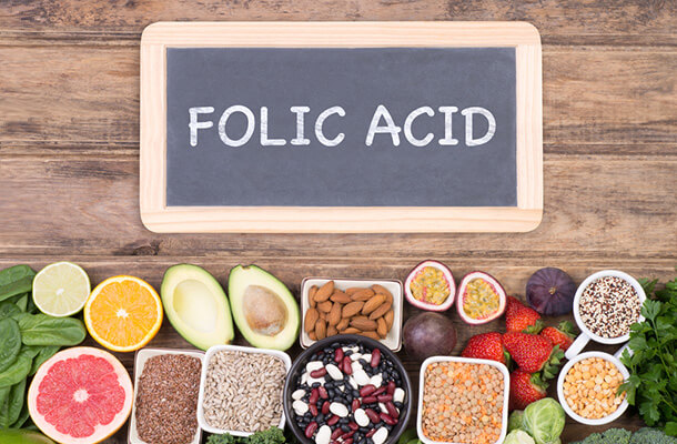folic acidと書かれたボードとたくさんの生の食材
