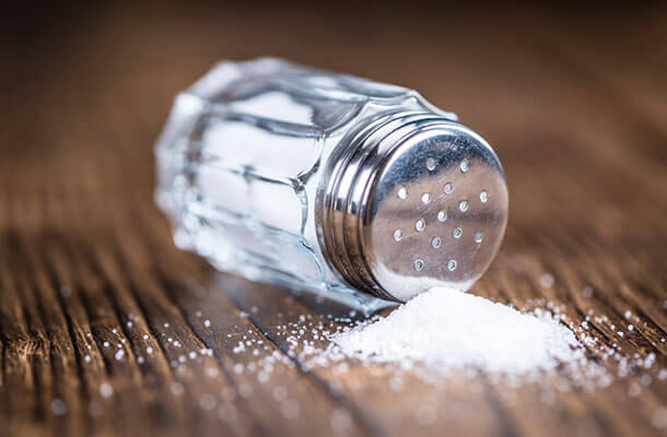 板の上に盛られた塩と倒れた小瓶